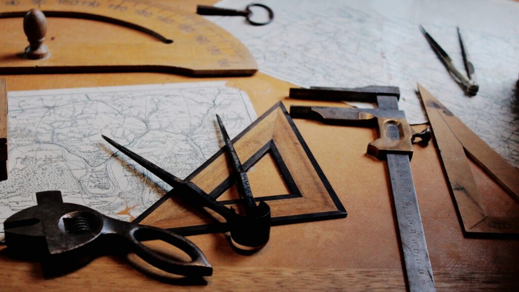 Ruler, compass and other measurement tools displayed on a desk.
