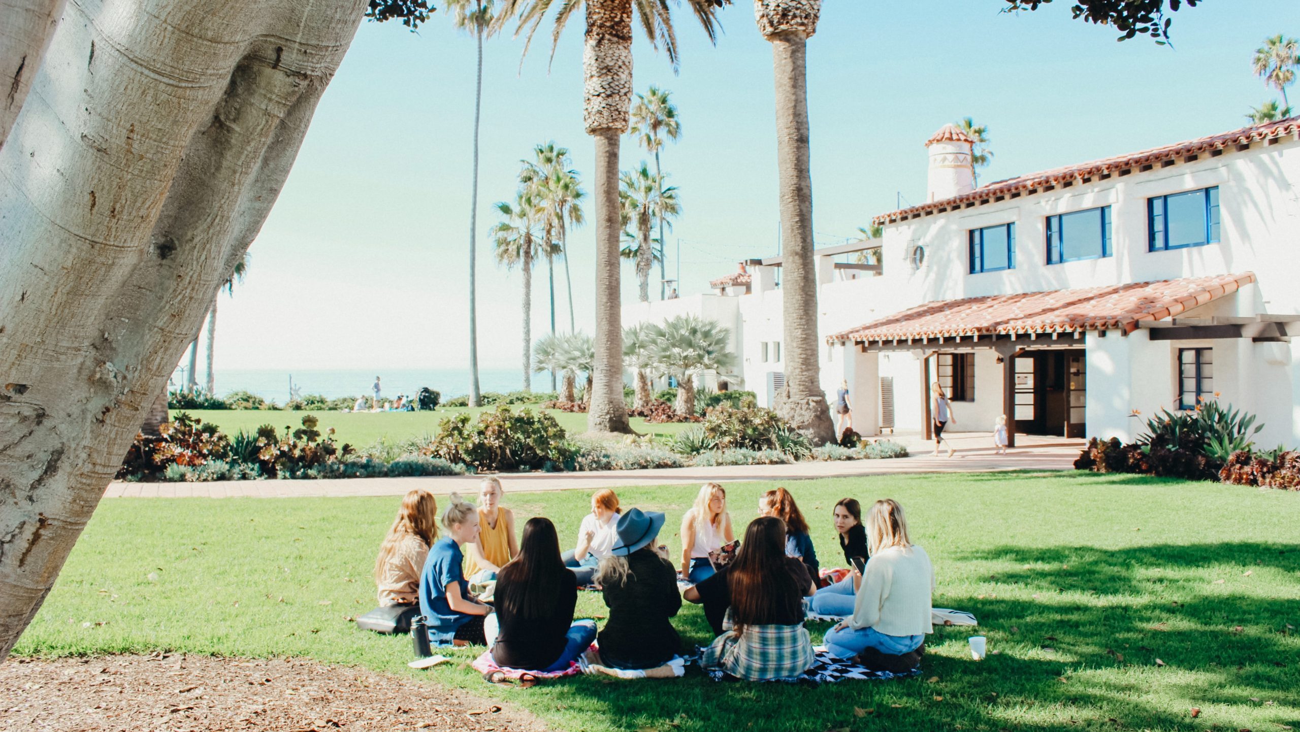 Students sitting in a circle on the lawn.