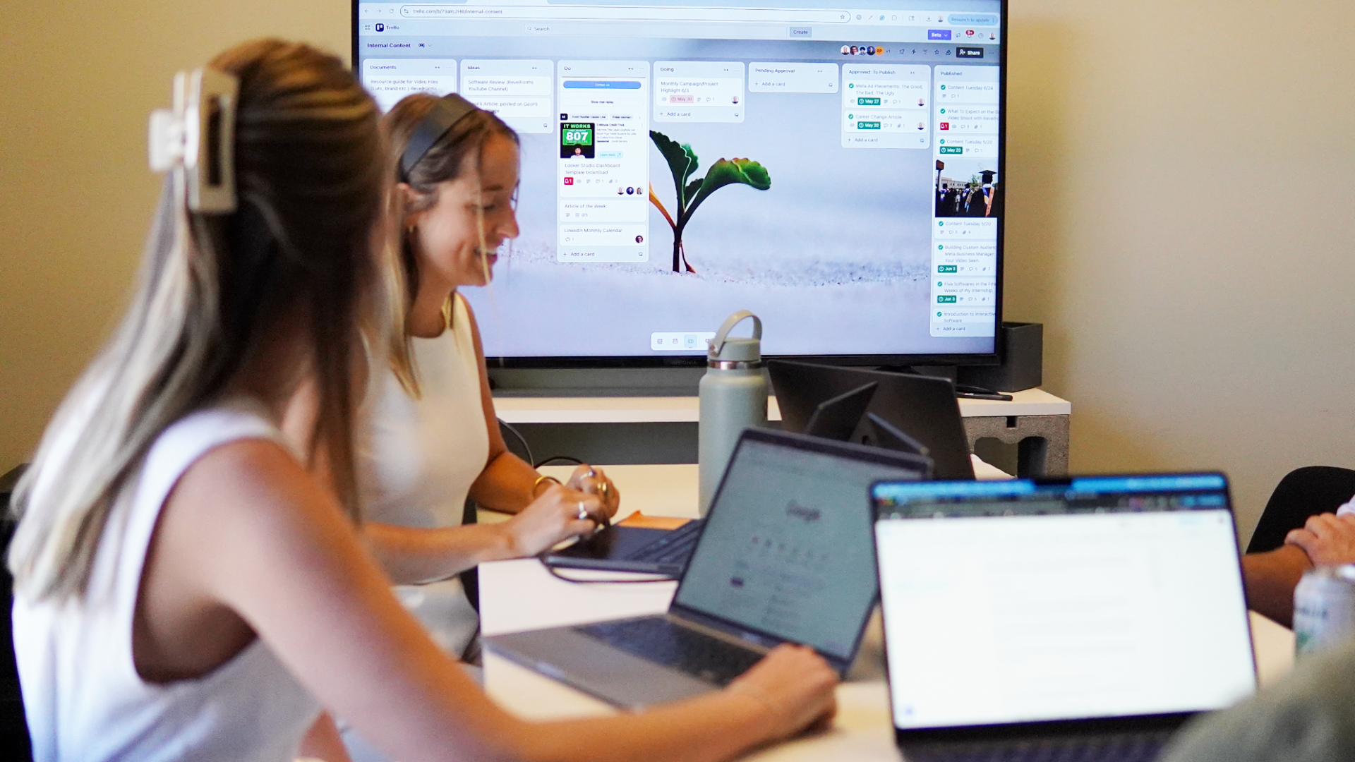 People working in an office, using laptops and having a discussion.